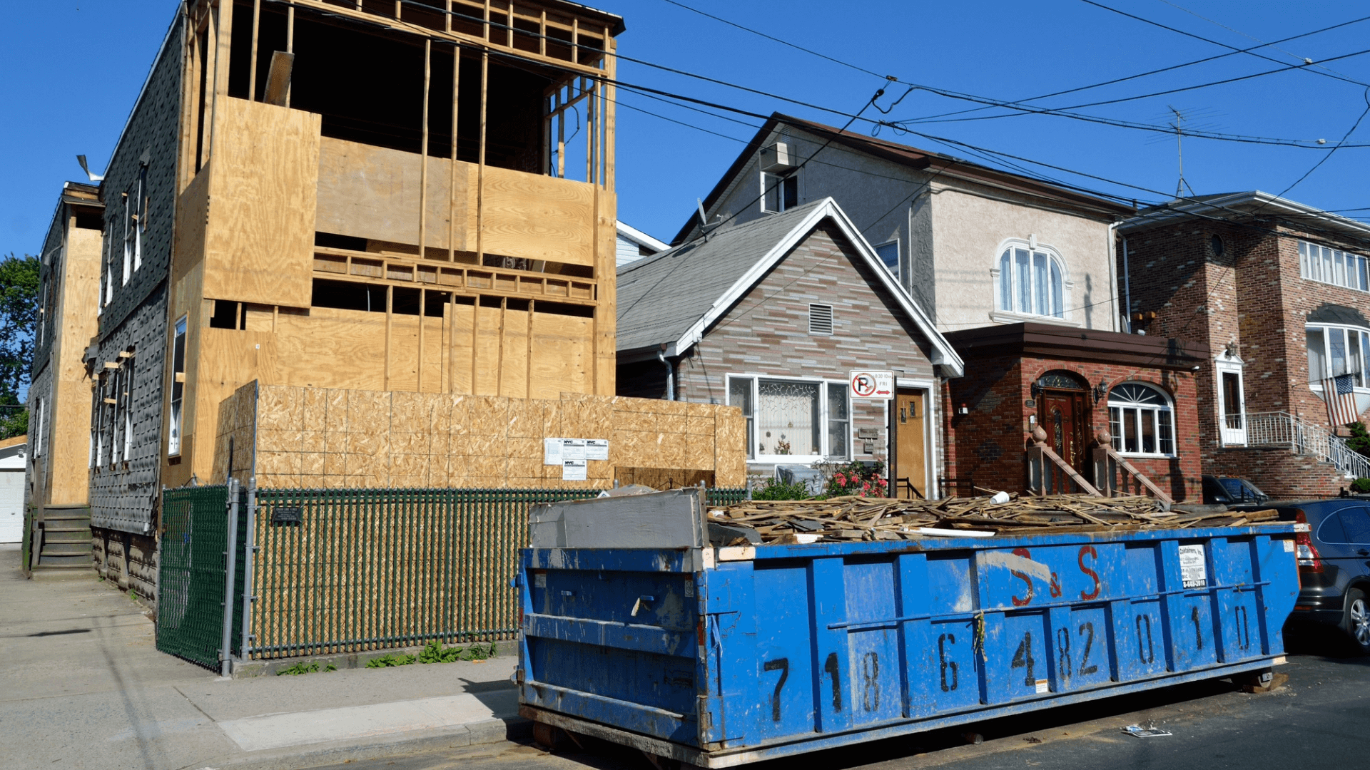 New condo being built with a Payless Roll-off Dumpster in front yard