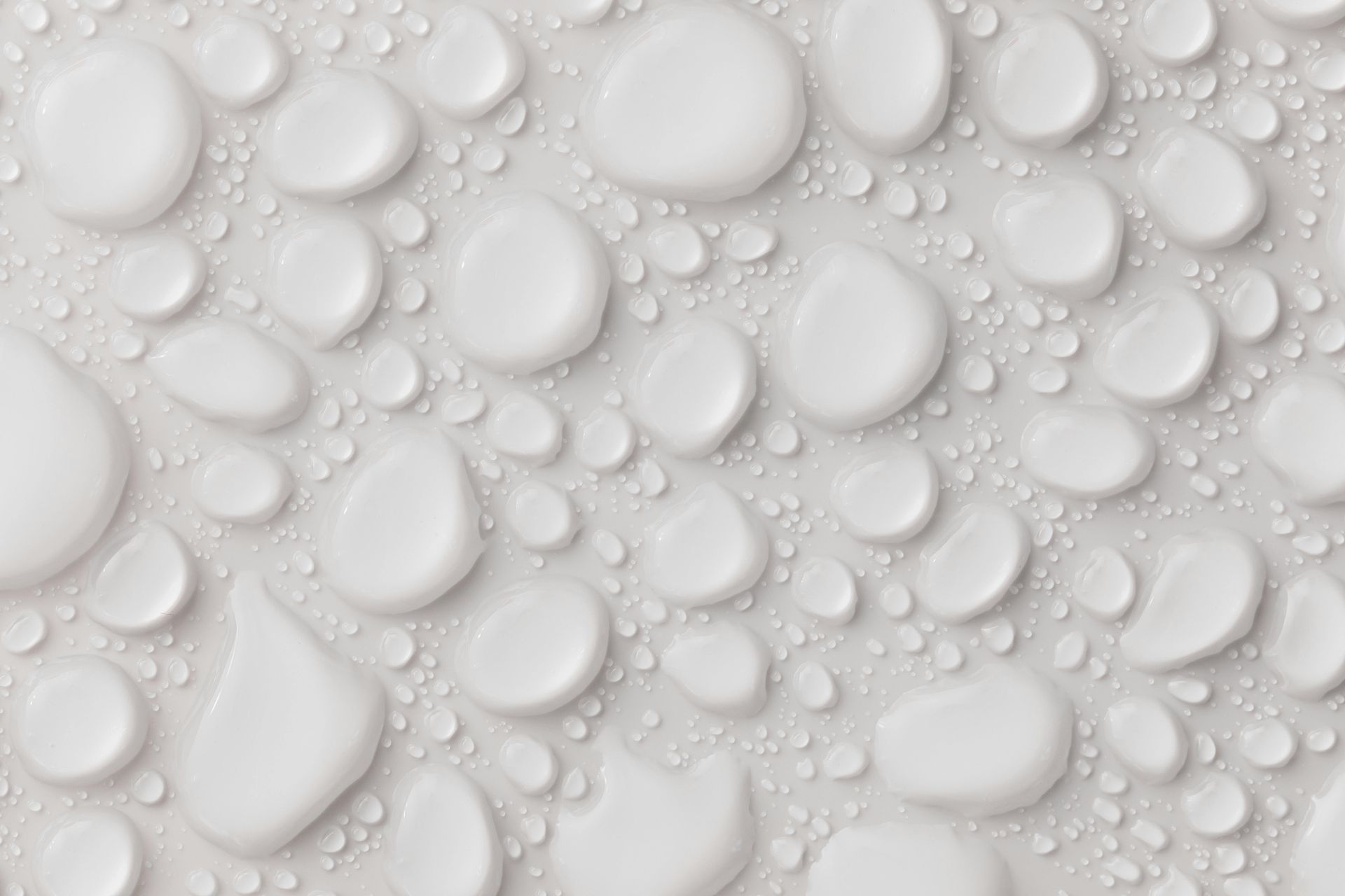 A close up of water drops on a white surface.