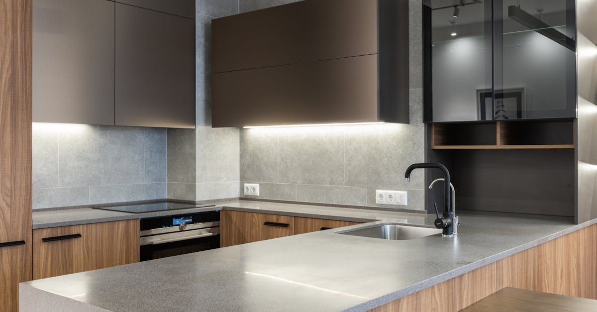 A kitchen with a sink , stove , and cabinets.