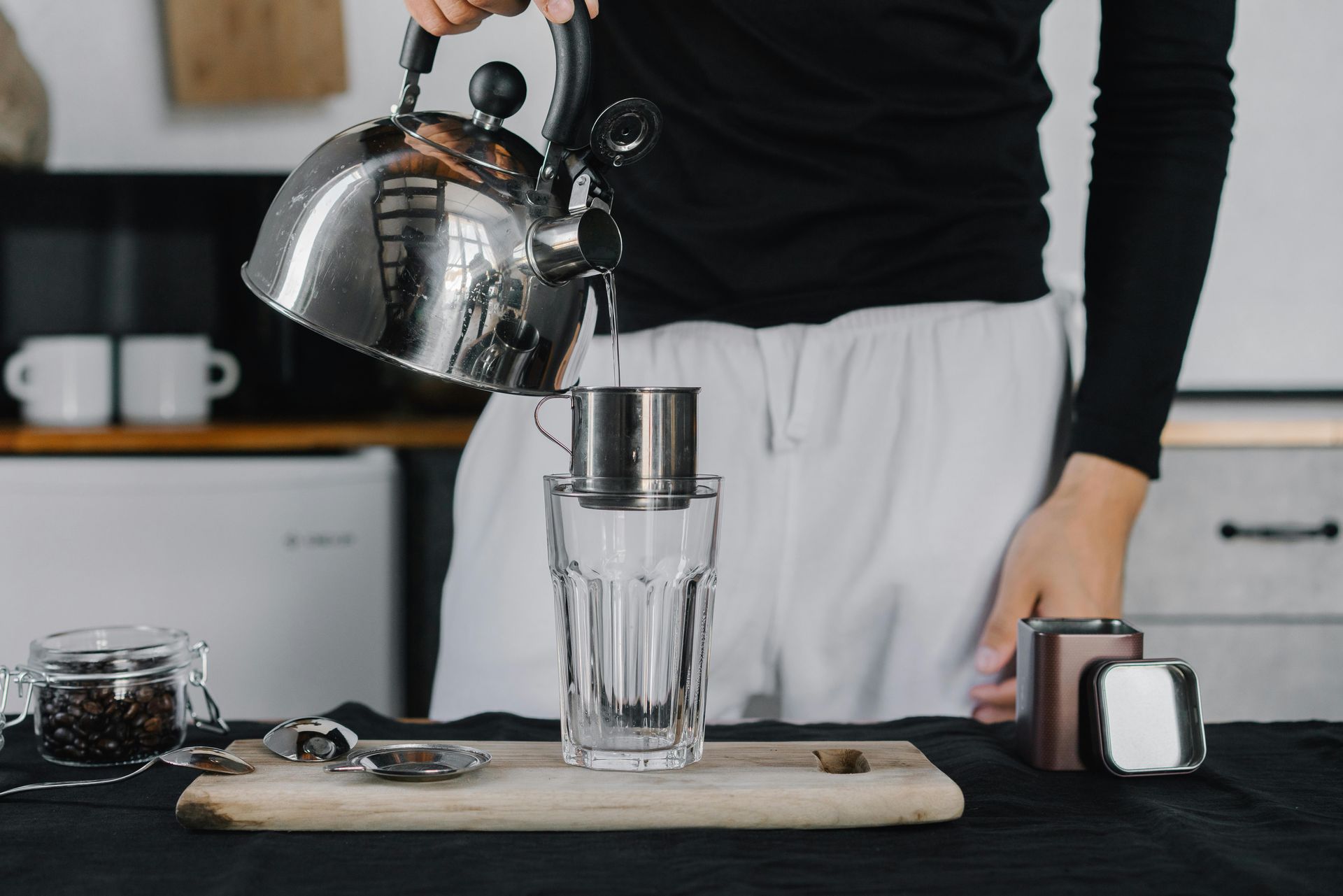 a woman is holding a plunger in a kitchen sink .