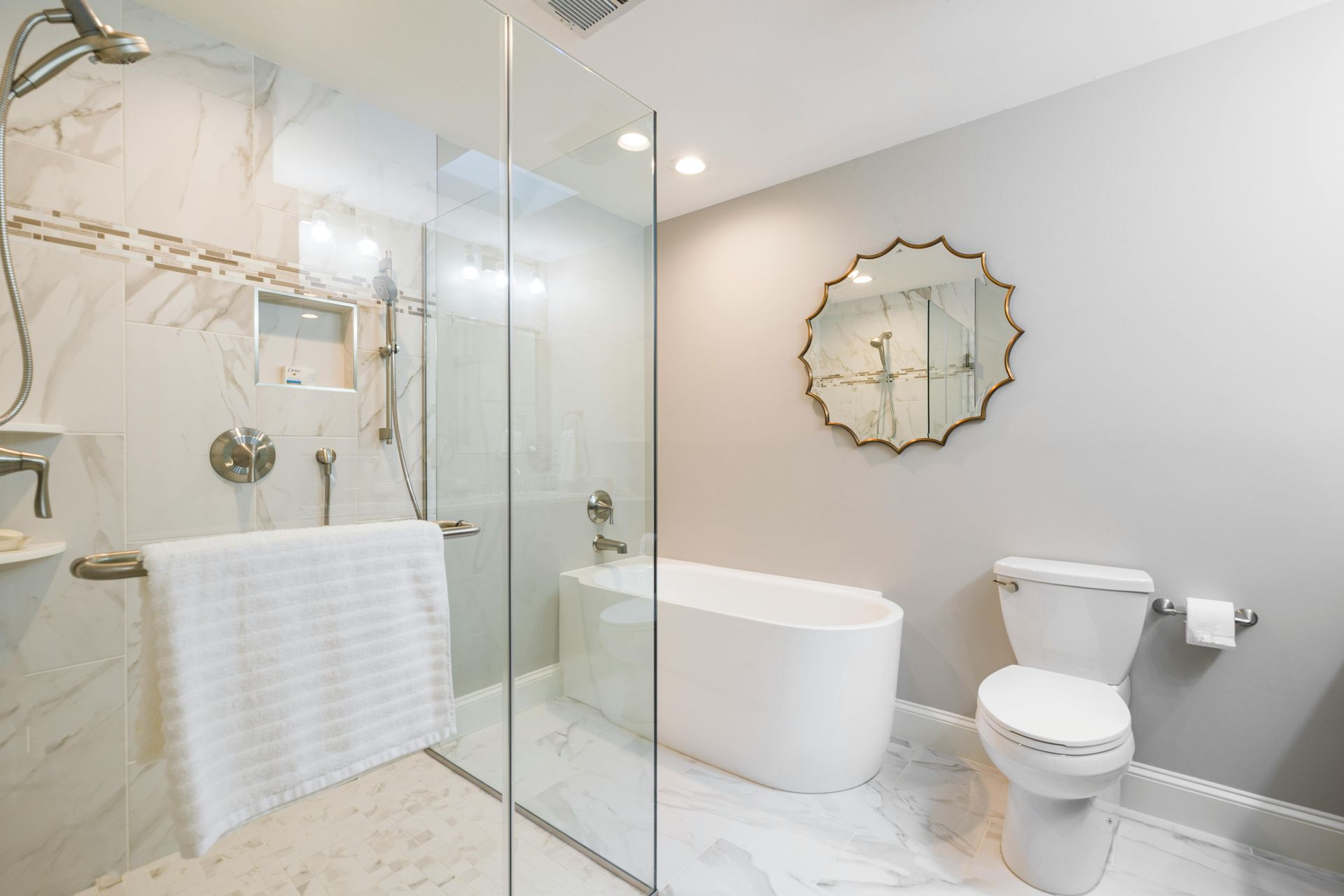 A bathroom with a tub , toilet , shower and mirror.