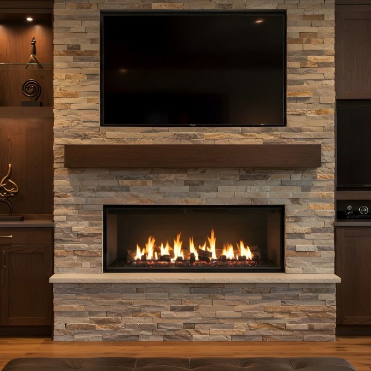 A stone fireplace with a built-in television, a dark wood mantel, and custom cabinetry on either side.