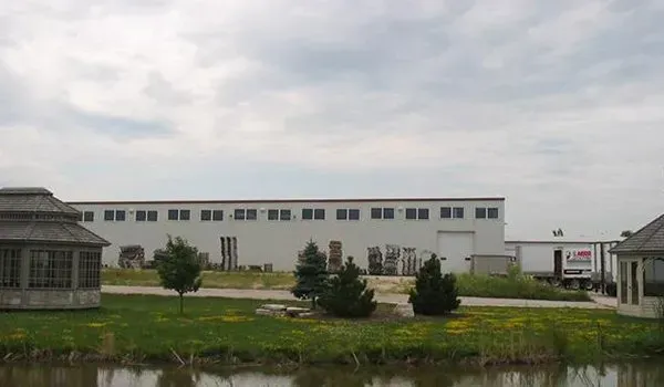 Empty industrial warehouse with steel beams, a high roof, and a concrete floor