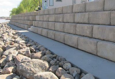 A stone wall with a lot of rocks in front of it