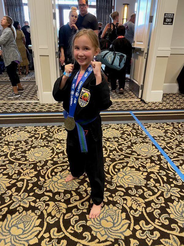 Young Girl wearing a karate uniform with her medal after winning the competition