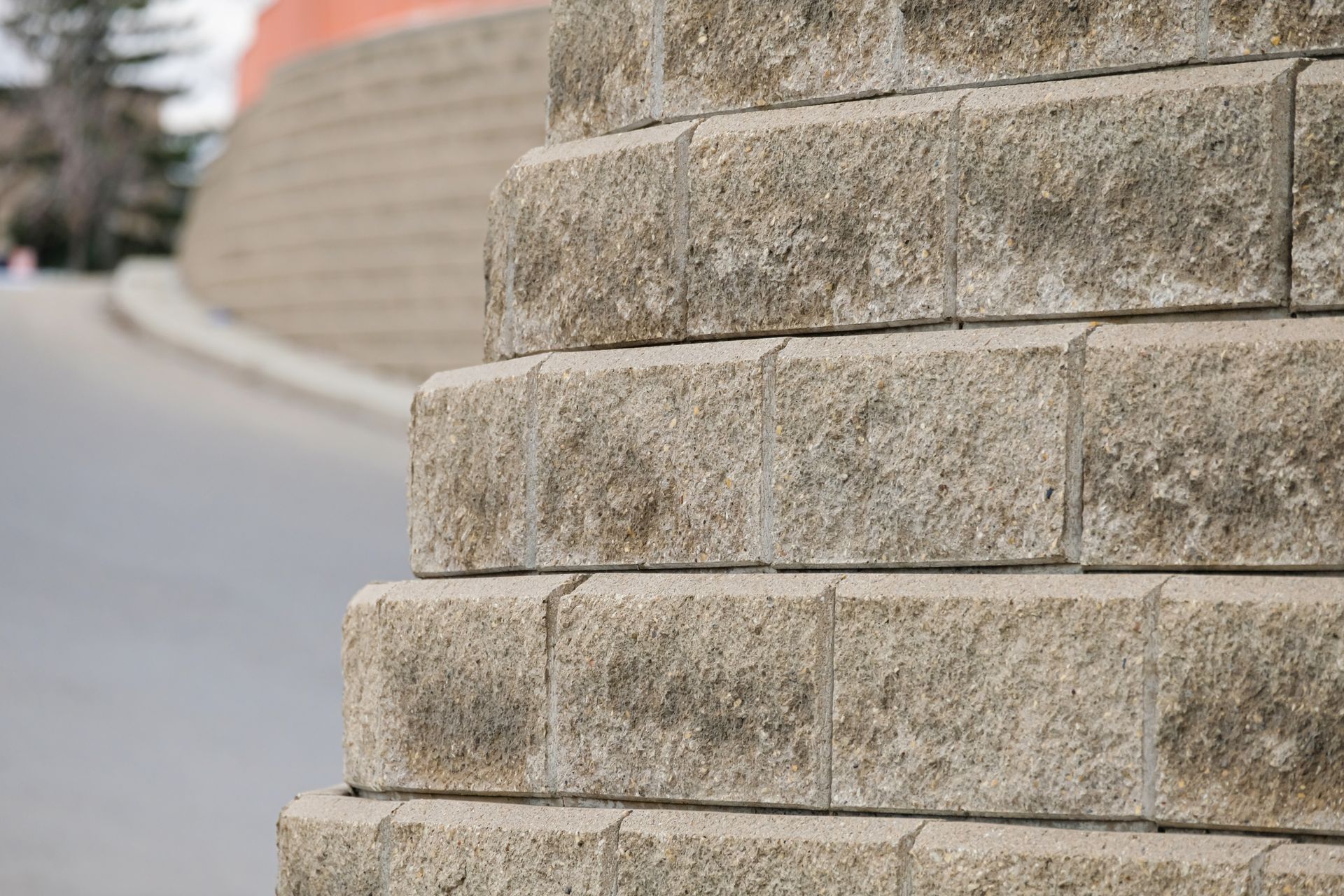 Close-up of a stone wall beside a curved roadside path Close-up of a stone wall beside a curved roadside path