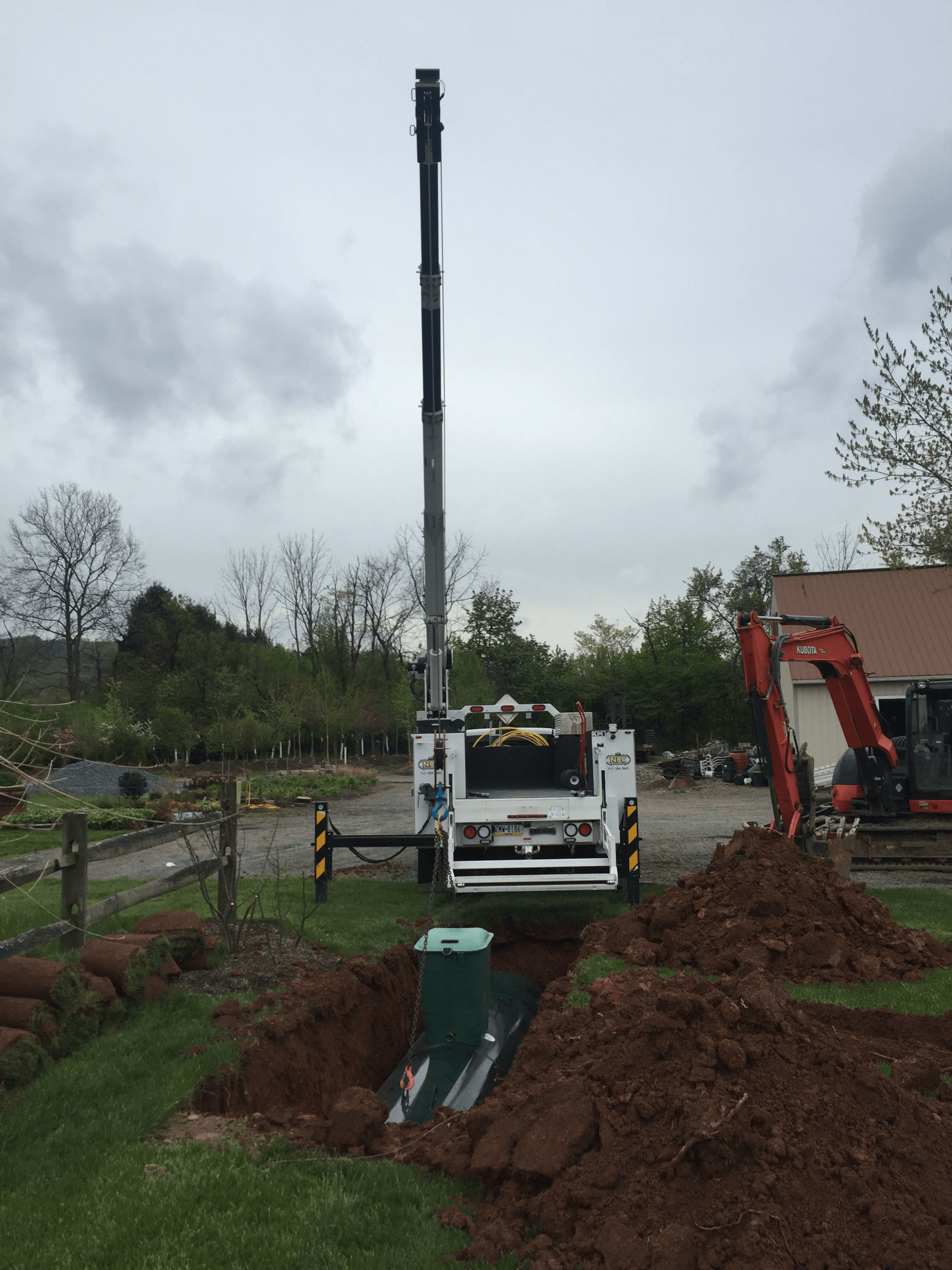 A crane is being used to dig a hole in the ground in front of a house — New Holland, PA — Nolts Propane Connections