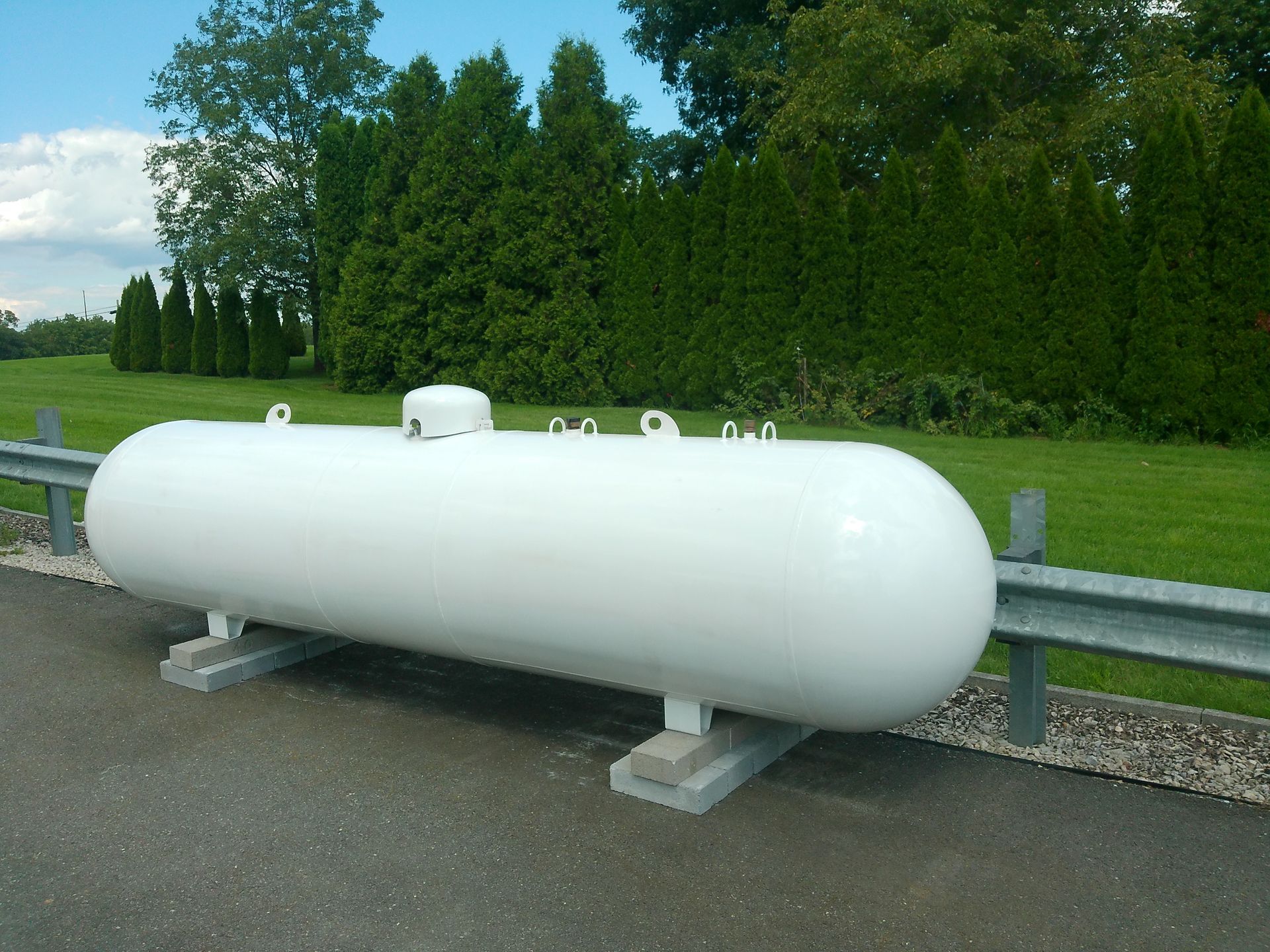 A Large White Propane Tank Sits on The Side of The Road