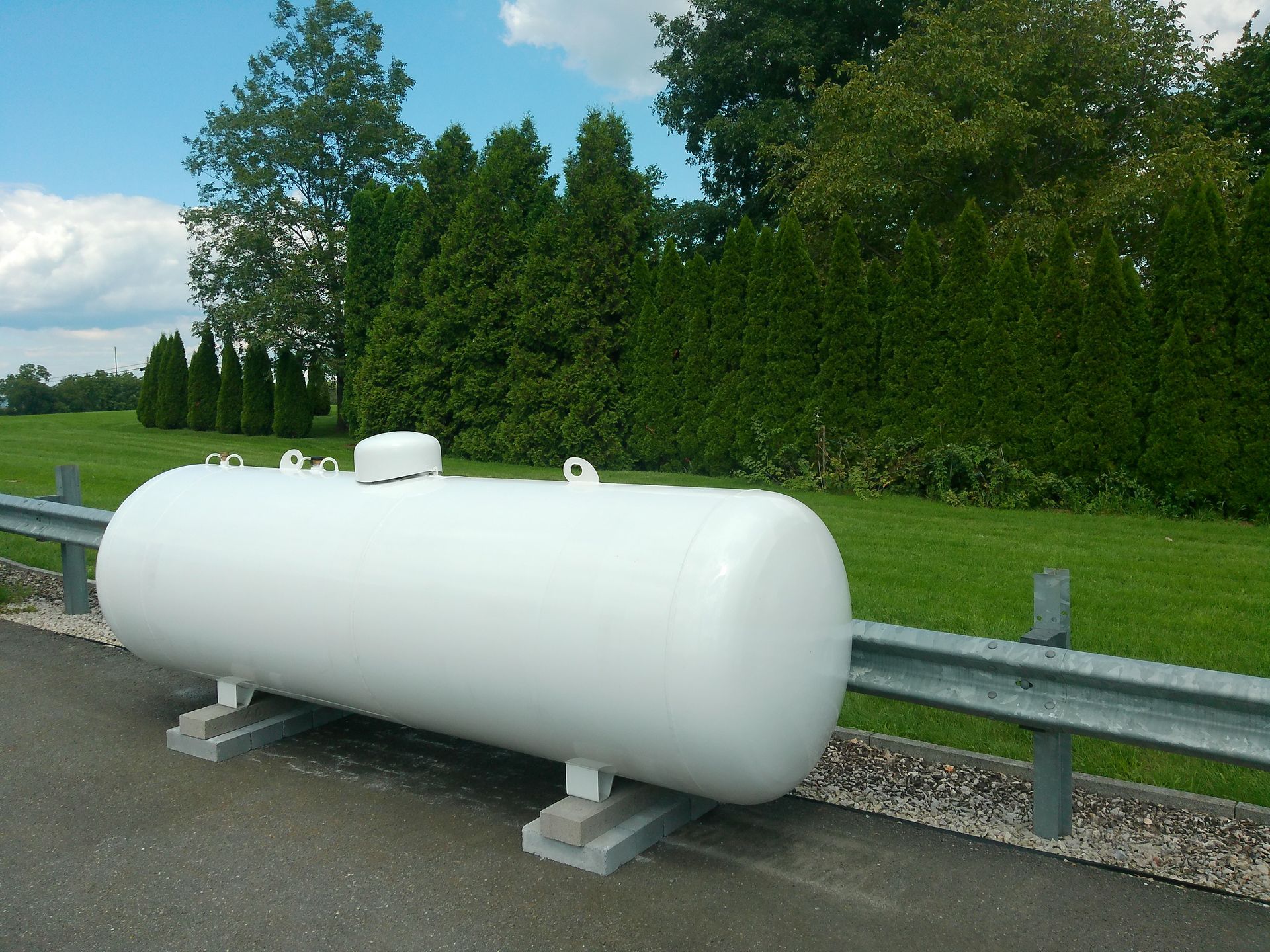 A Large White Tank Sits on The Side of A Road