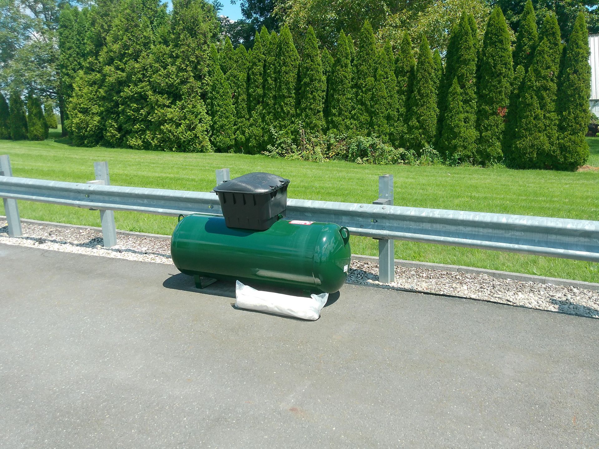 A Green Tank Is Displaying on The Side of The Road 