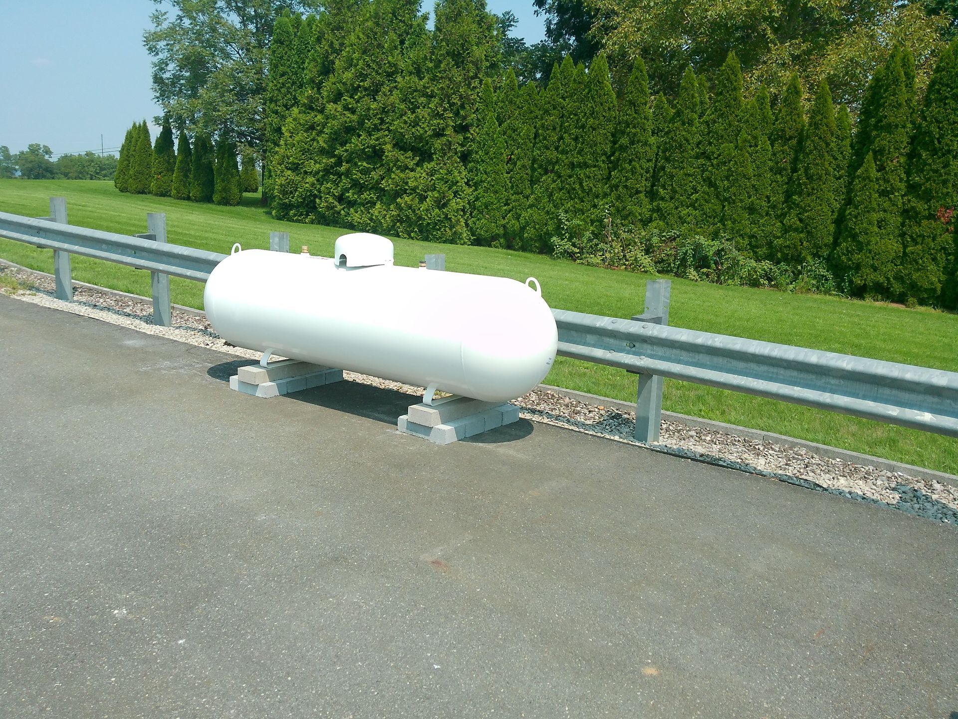 A Large White Tank Sits on The Side of A Road So Far View