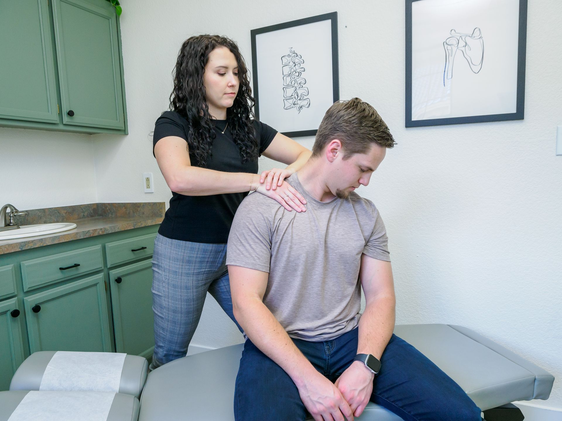 A woman is giving a man a massage in a room.
