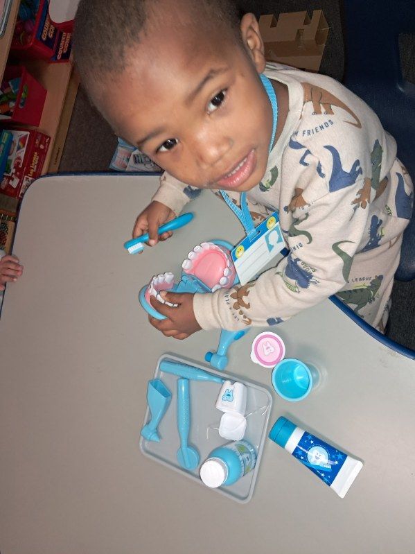 A young boy is sitting at a table drawing on a piece of paper