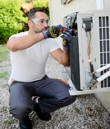 Man Repairs the Air Conditioner — Lubbock, TX — Ricky Boyce Plumbing, Heating & Air Conditioning