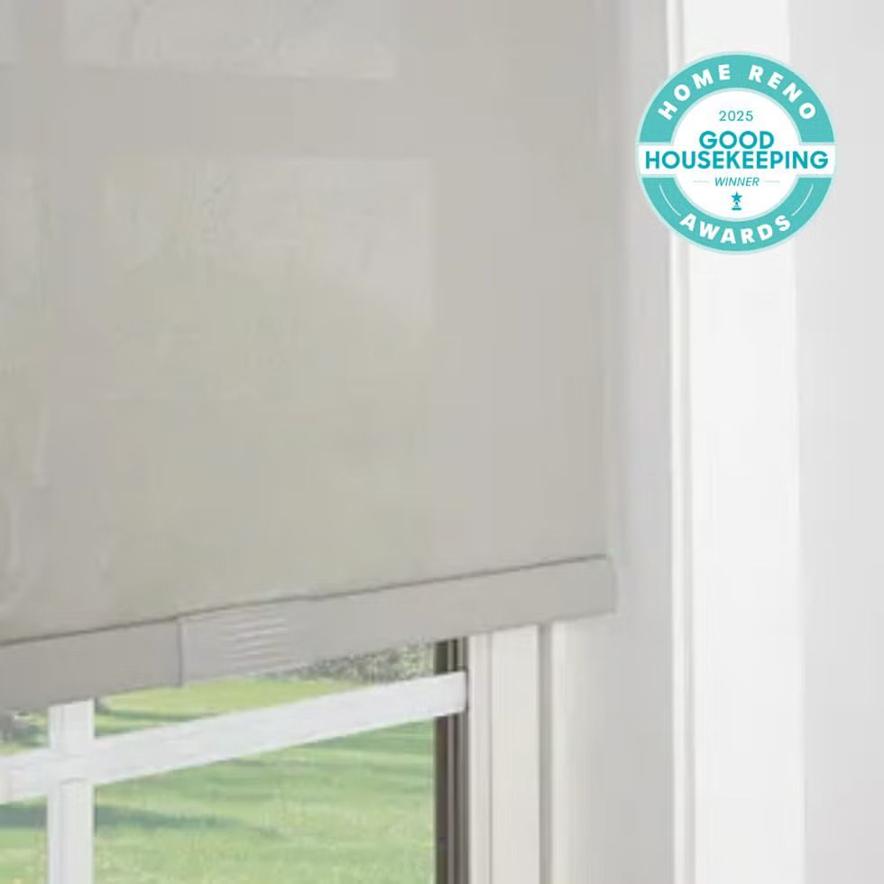 Close-up of a light-colored roller shade covering a window, with a