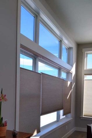 Large windows with cellular shades; bright blue sky visible.