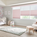 Pink blinds in a nursery with crib, floral wallpaper, and fluffy rug.