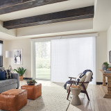 Living room with white panel blinds covering a large sliding glass door.