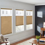 Three windows with beige cellular shades in a bright, modern room.