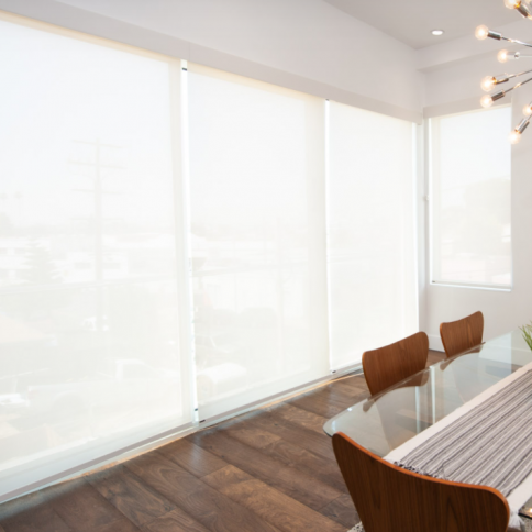 Bright dining room with white blinds, a glass table, wooden chairs, and a hardwood floor.