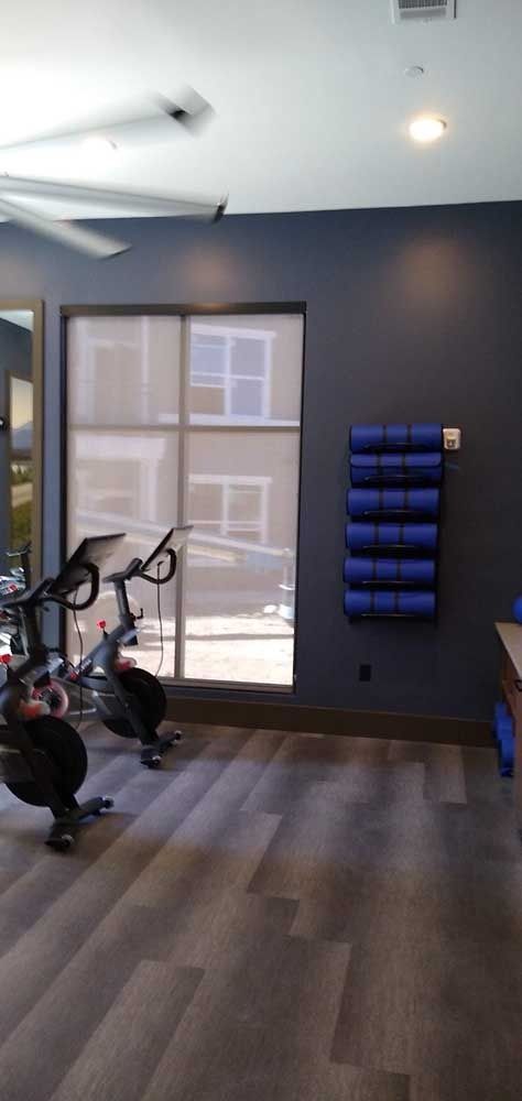 Gym interior with exercise bikes, yoga mats, and a window.