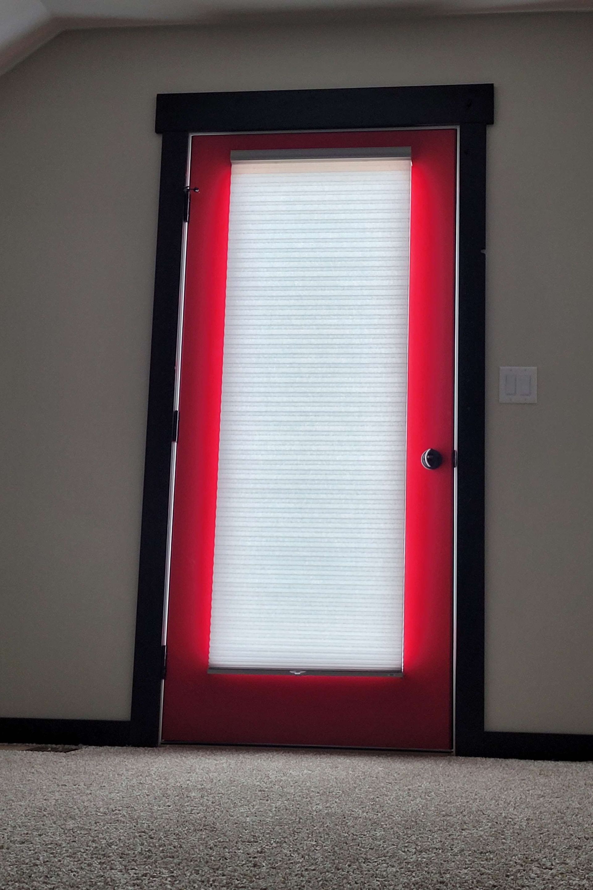 Red door with black trim and white blinds.