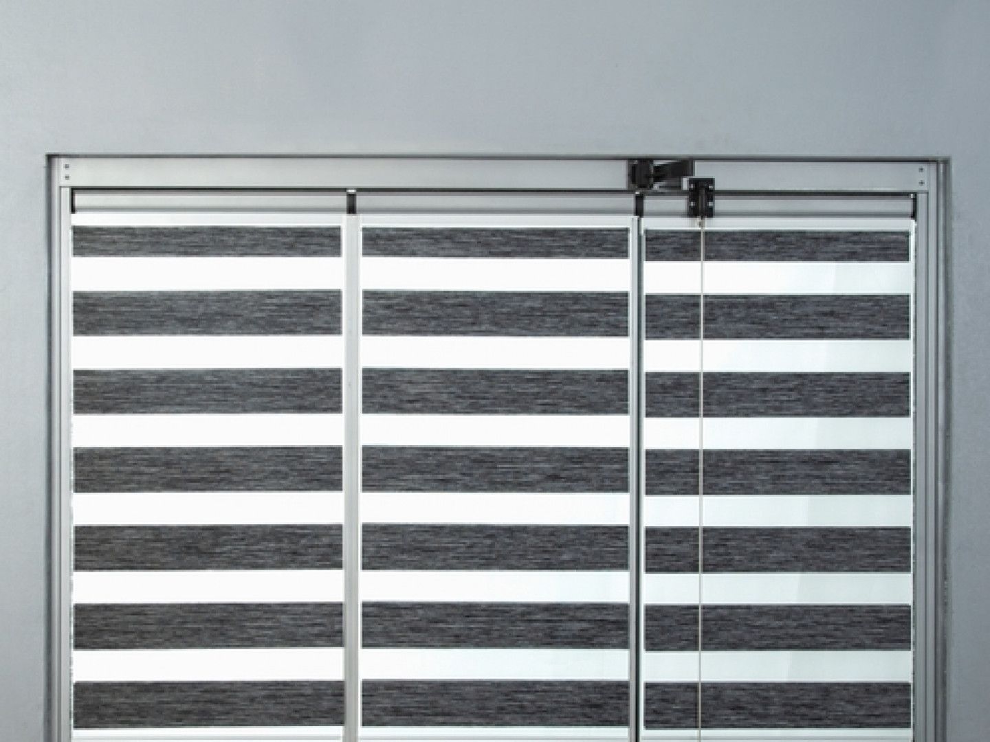 Three sectioned zebra blinds with alternating white and grey stripes.