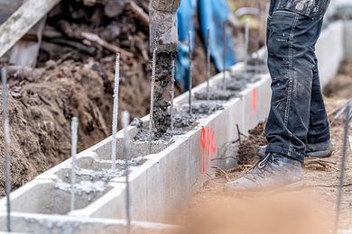 a man standing next to a pile of cement