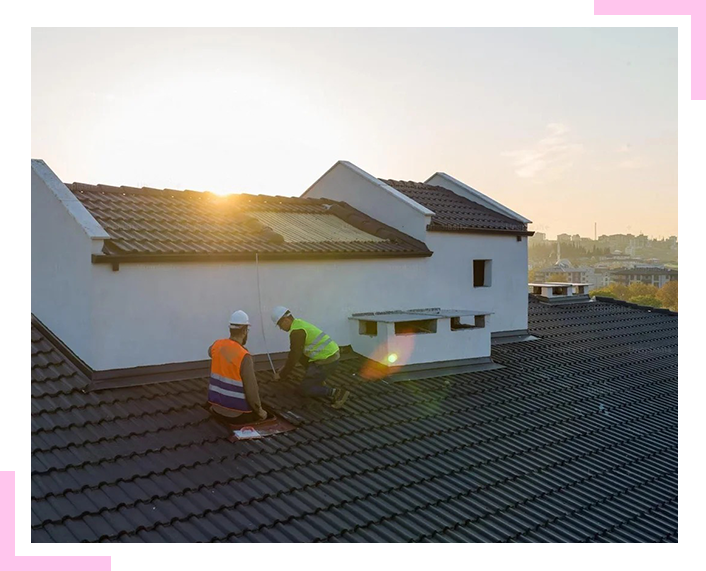 Two men are working on the roof of a building.