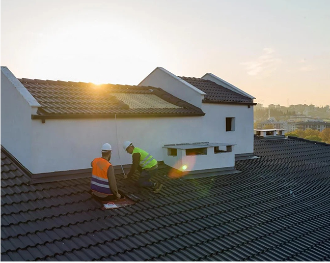 Two men are working on the roof of a house