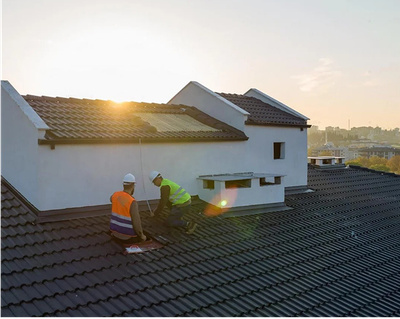 Two men are working on the roof of a house