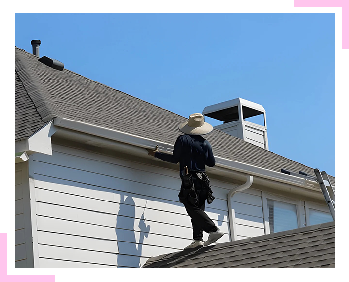 A man is standing on the roof of a house.