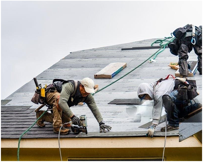 A group of men are working on a roof.