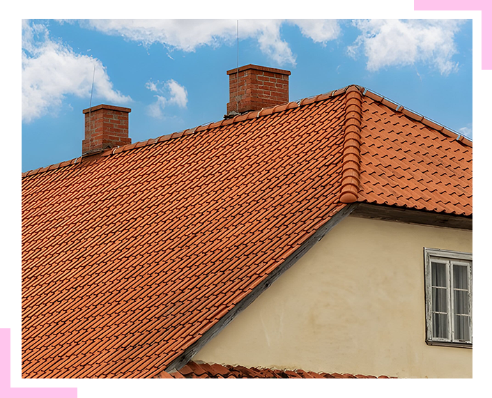 A house with a tiled roof and chimneys on top of it.