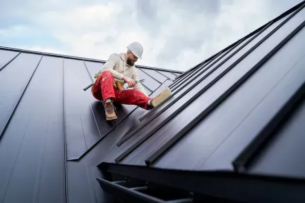 A man is sitting on the roof of a building.