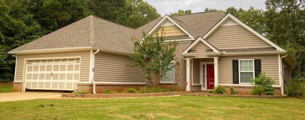 A house with a large garage and a red door