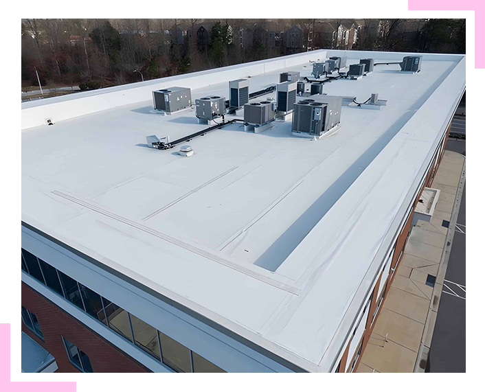 An aerial view of a large building with a white roof.