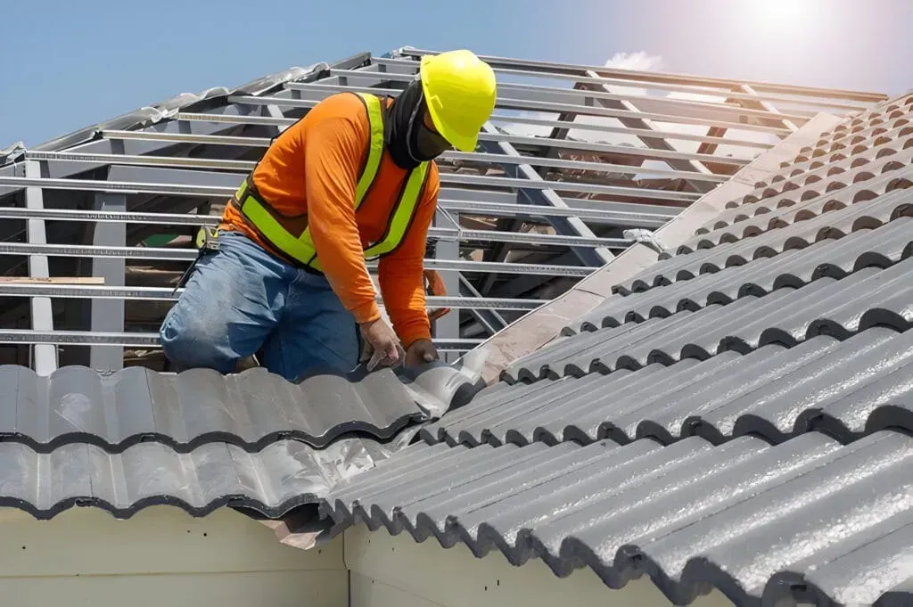 A construction worker is working on the roof of a building.