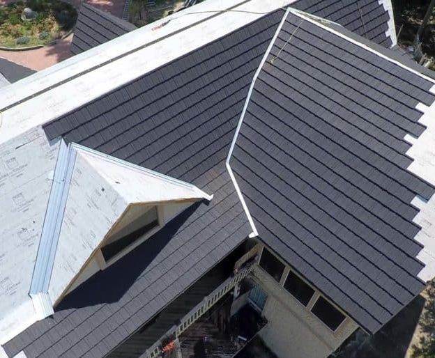 An aerial view of a house with a black roof