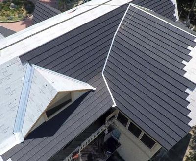 An aerial view of a house with a black roof