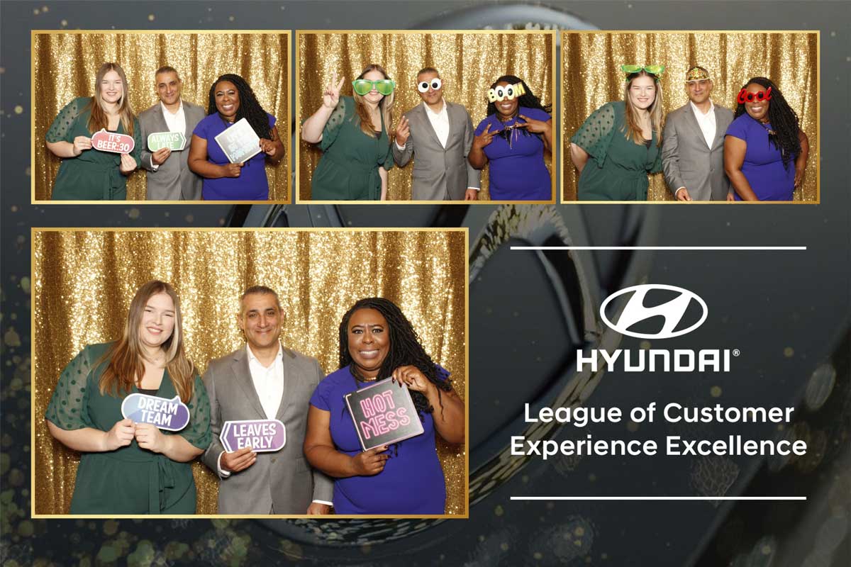 A group of people are posing for a photo in a hyundai photo booth.