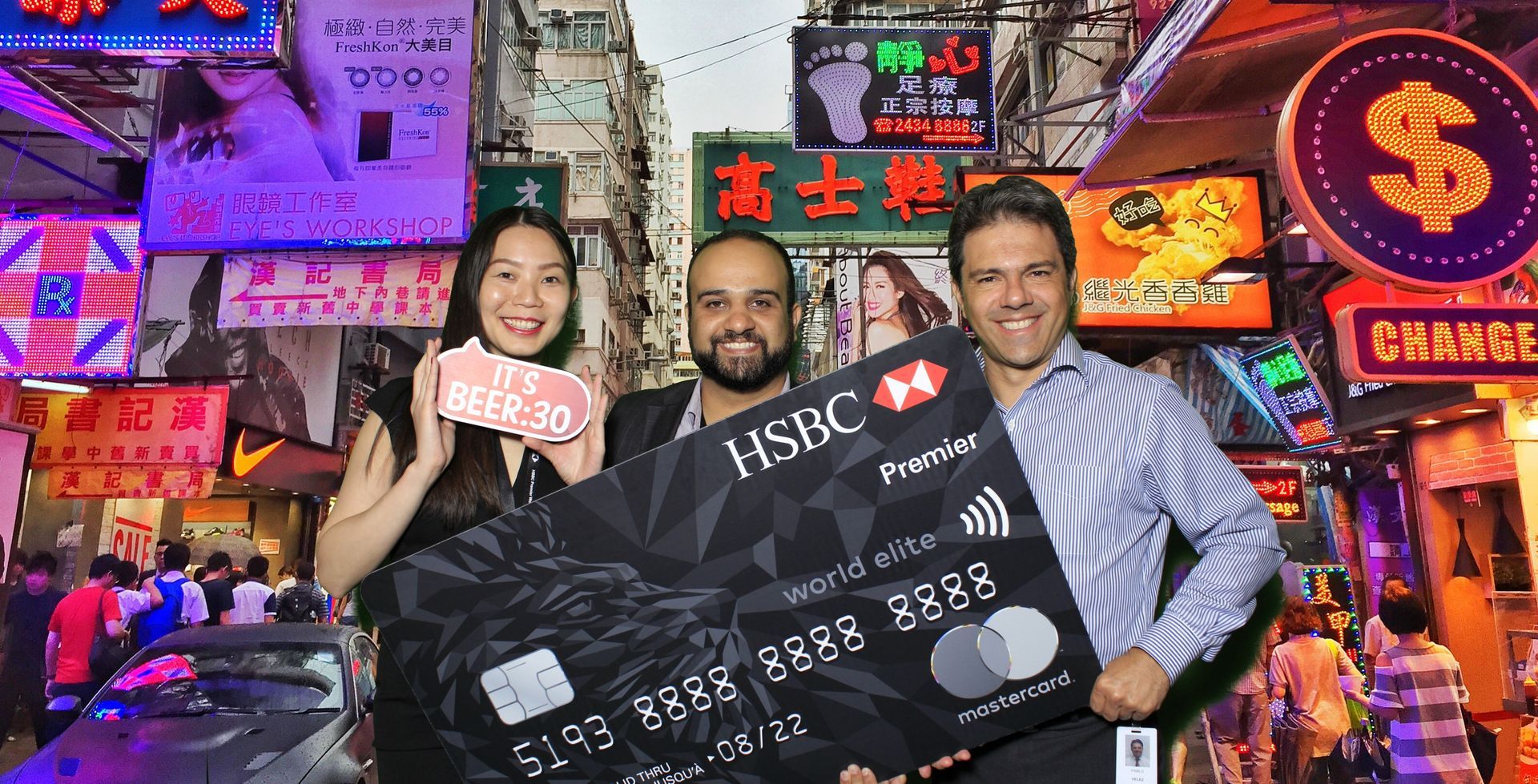 A group of people standing next to each other holding a hsbc credit card.  Greenscreen image of a street in Hong Kong.  Image provided by LOL Photo Booth GTA.