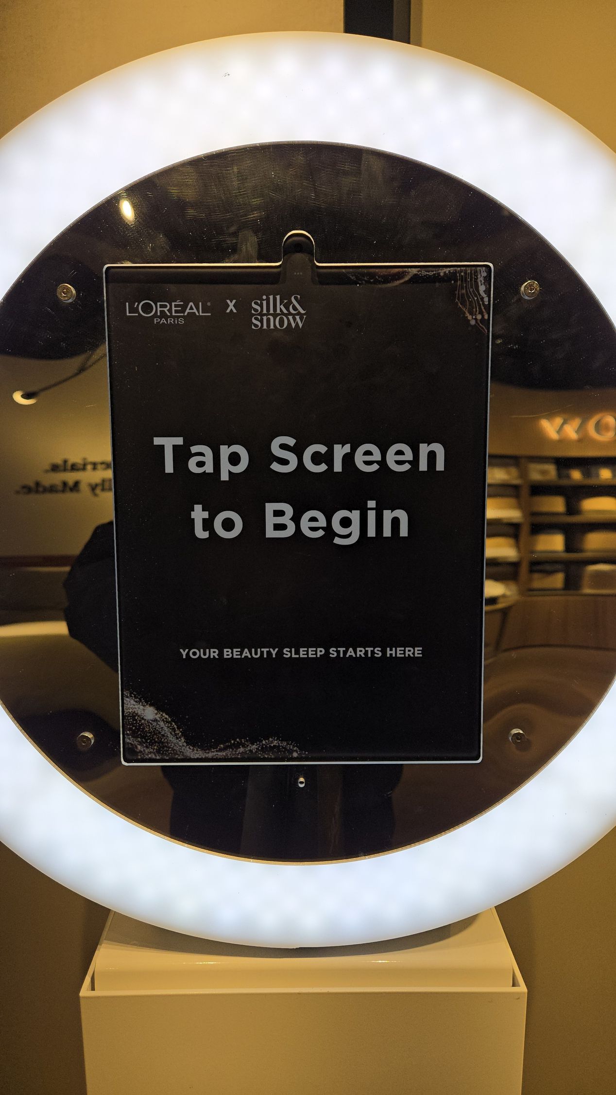 Photo booth with a glowing ring light and a screen that reads 