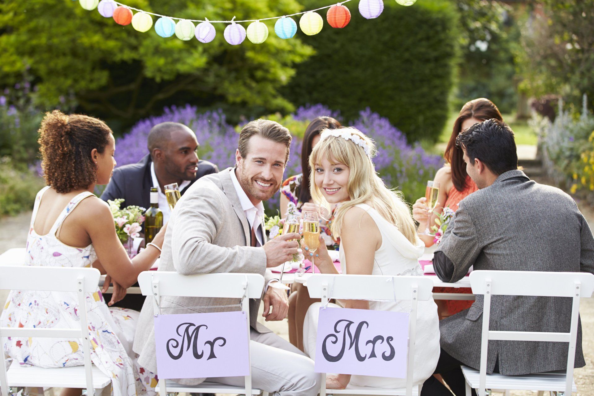 A group of people are sitting at a table at a wedding reception.