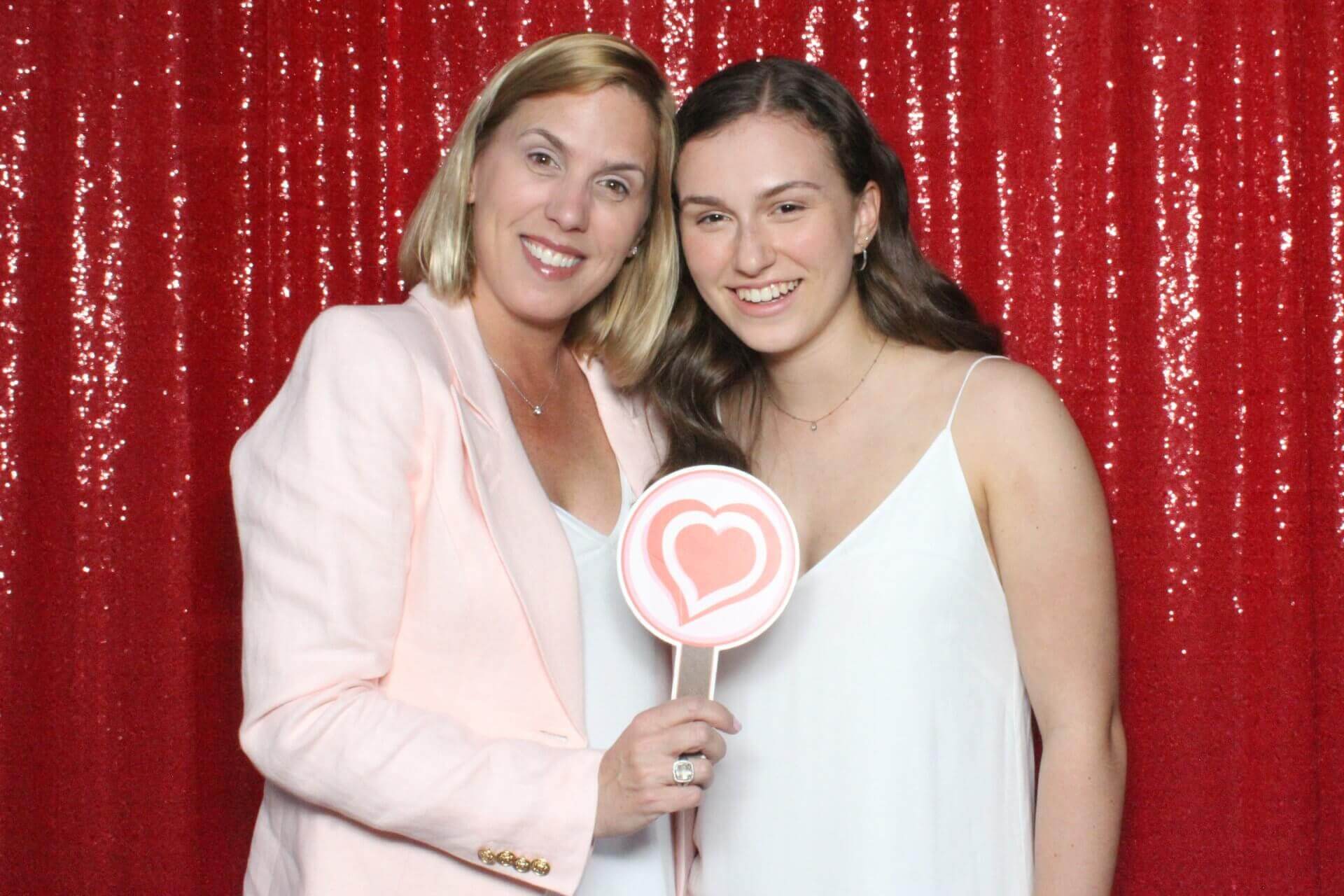 Photo booth rental in Toronto for an event. Posing in front of a red sequin backdrop offered by LOL Photo Booth. Tags: Event planning ideas, Photo booth prints, high resolution photos, Toronto photo booth rental services. GIFS, Boomerangs, Mosaic Walls, Slow motion, brand activation.