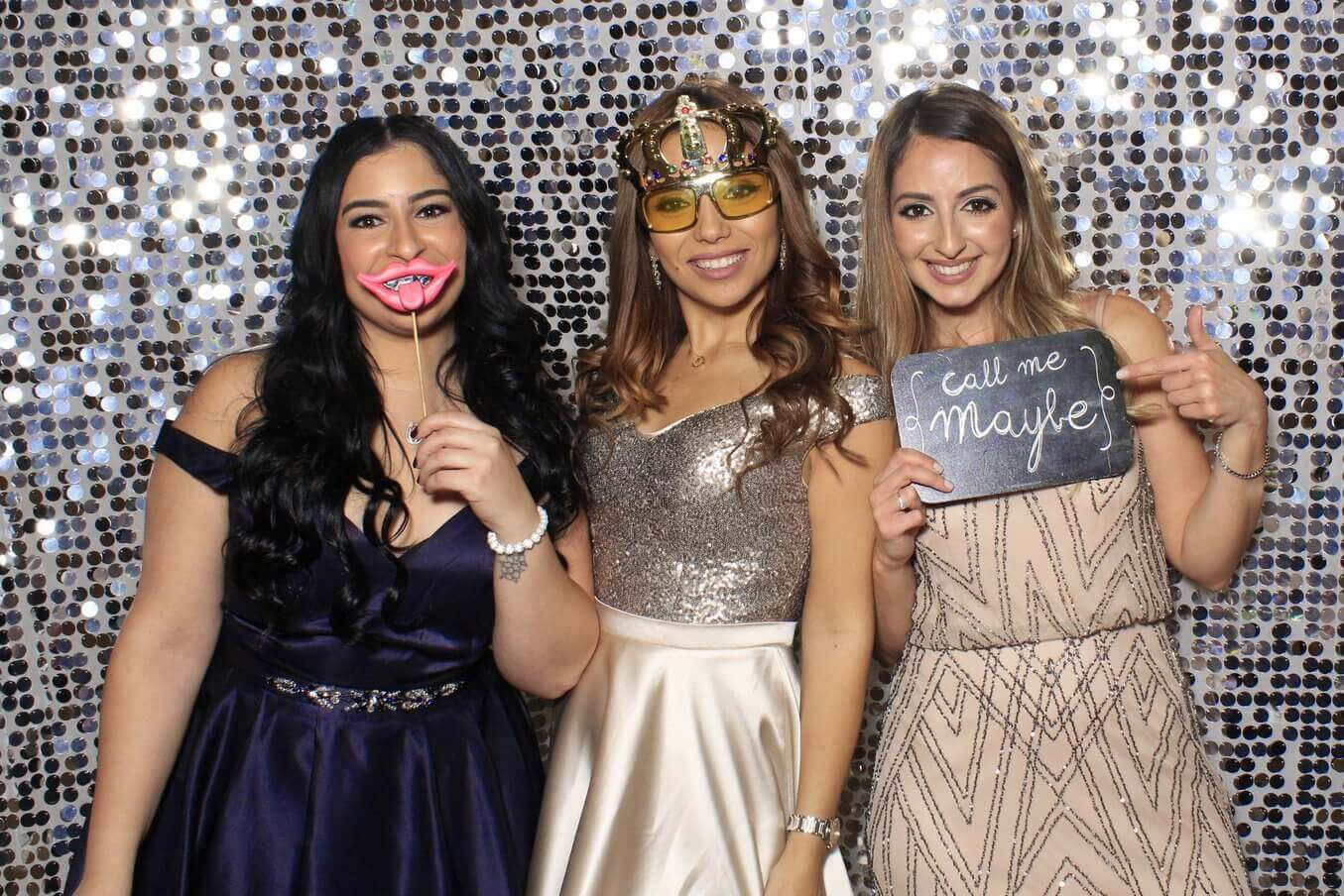 Photo booth rental in Toronto for a wedding. Posing in front of a silver coin backdrop offered by LOL Photo Booth. Tags: Event planning ideas, Photo booth prints, high resolution photos, Toronto photo booth rental services. GIFS, Boomerangs, Mosaic Walls, Slow motion, brand activation.