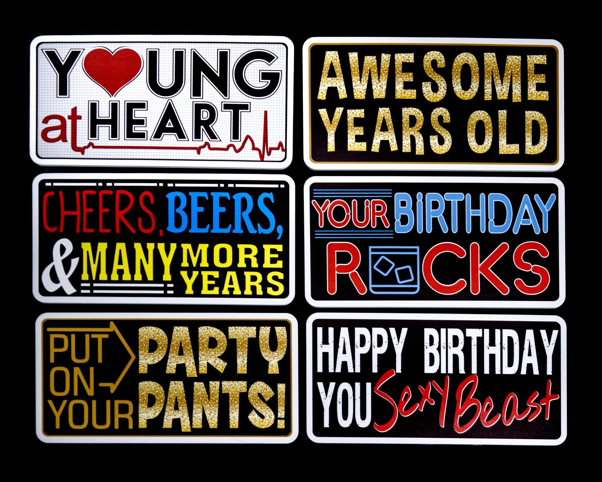 A bunch of signs that say ' young at heart ' and ' awesome years old '