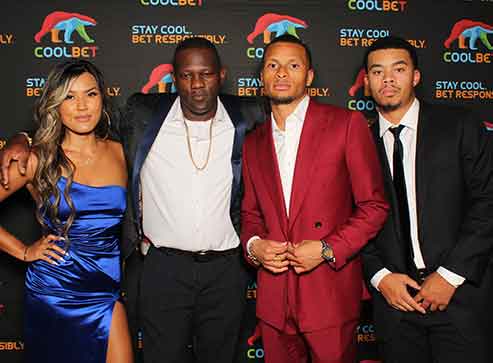 A group of people standing next to each other on a red carpet.