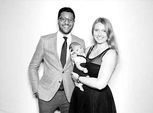 A black and white photo of a man and woman holding a baby.