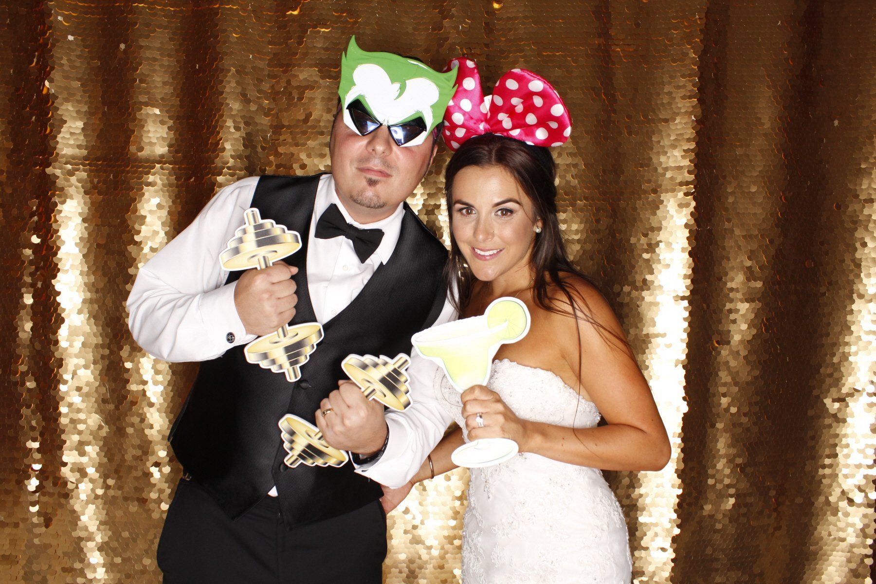 A bride and groom are posing for a picture in a photo booth.